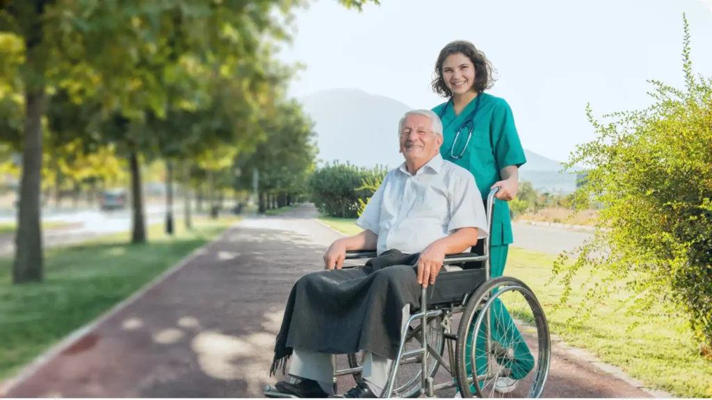 tekerlekli sandalyedekş hastanın yanında bakıcısı
