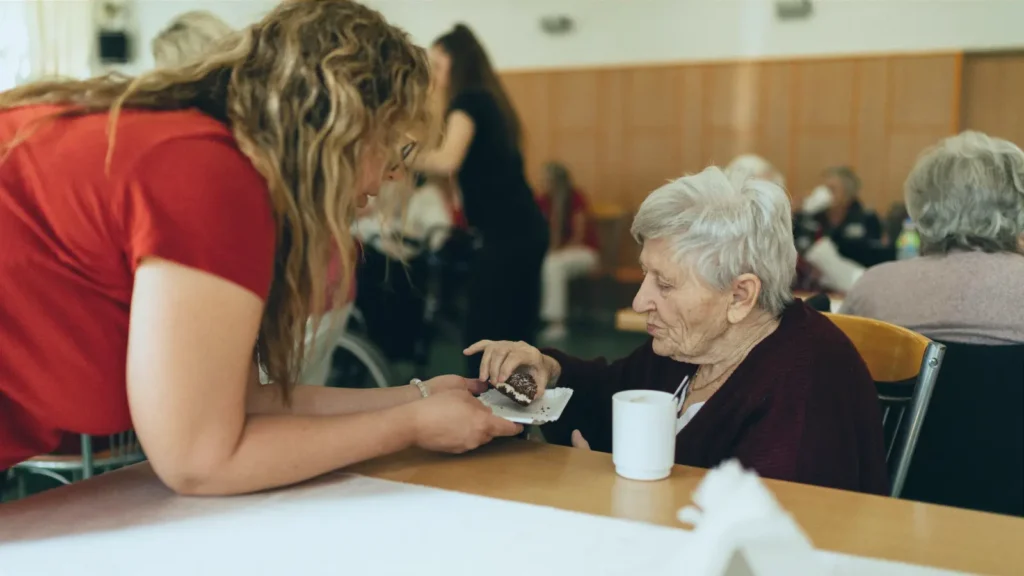 yaşlı bakıcısı yaşlının yemesine destek olur
